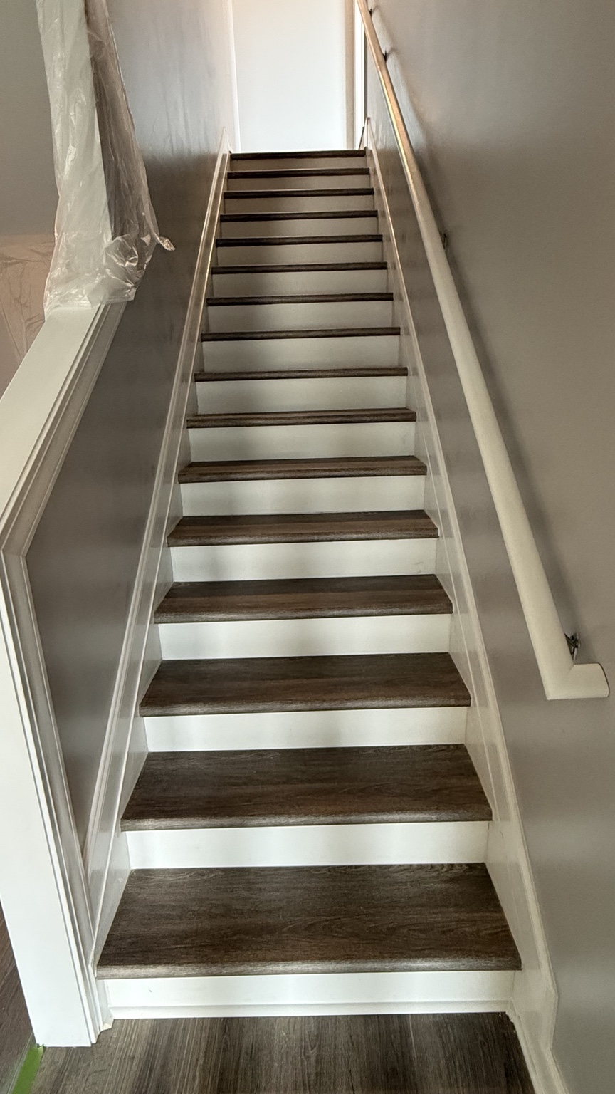 Installed dark wood-look stair treads with white risers